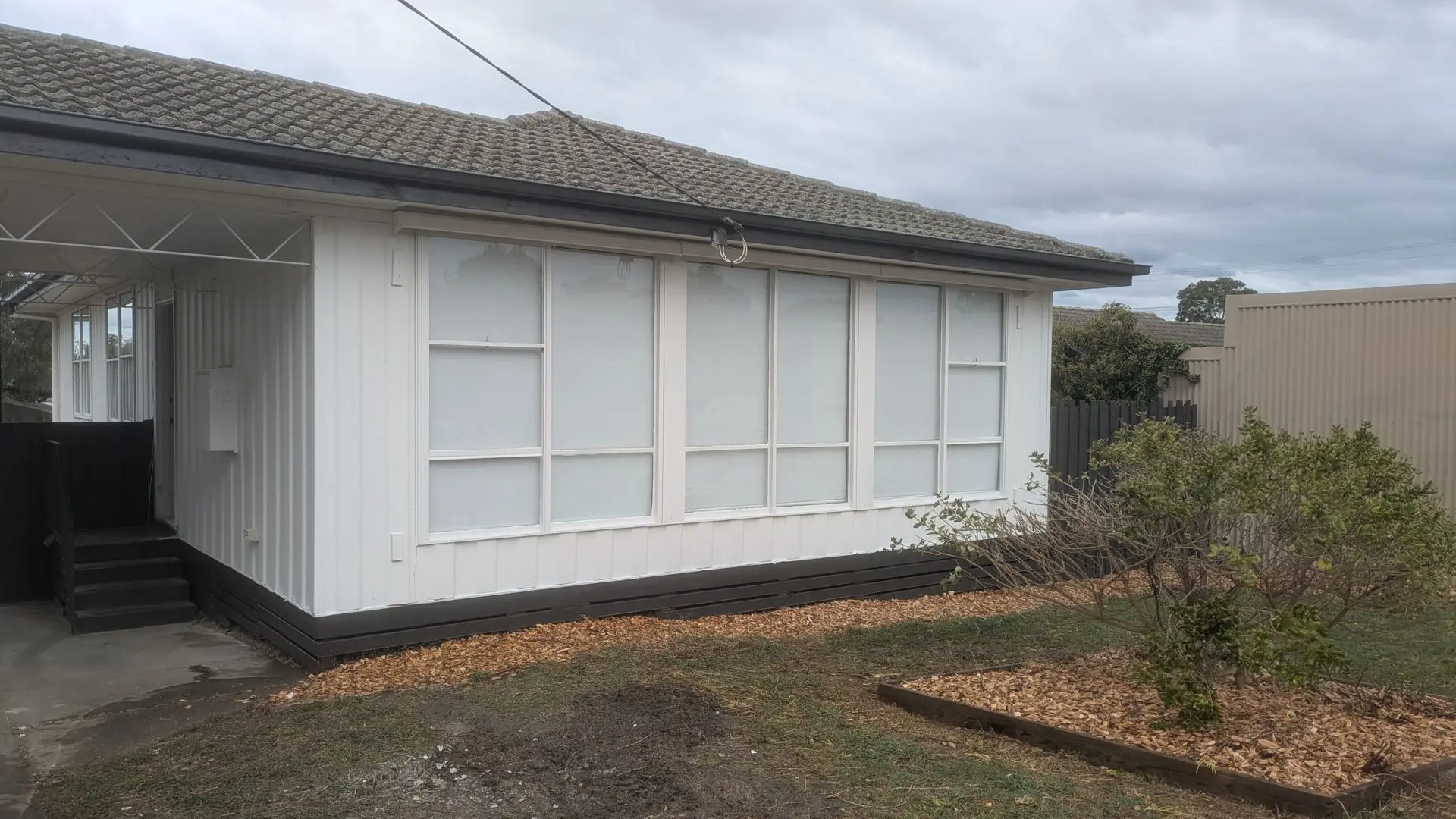 Backyard and exterior renovation in Morwell showing refreshed landscaping, clean, and bright home appearance.