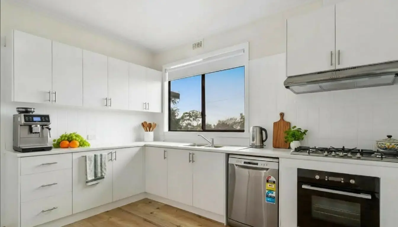 White benchtops for a crisp Modern kitchen renovation Morwell with white Polytec cabinetry and hybrid flooring