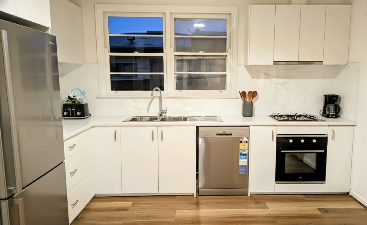 Full kitchen transformation featuring soft-close drawers, 600mm appliances, and laminate white benchtops