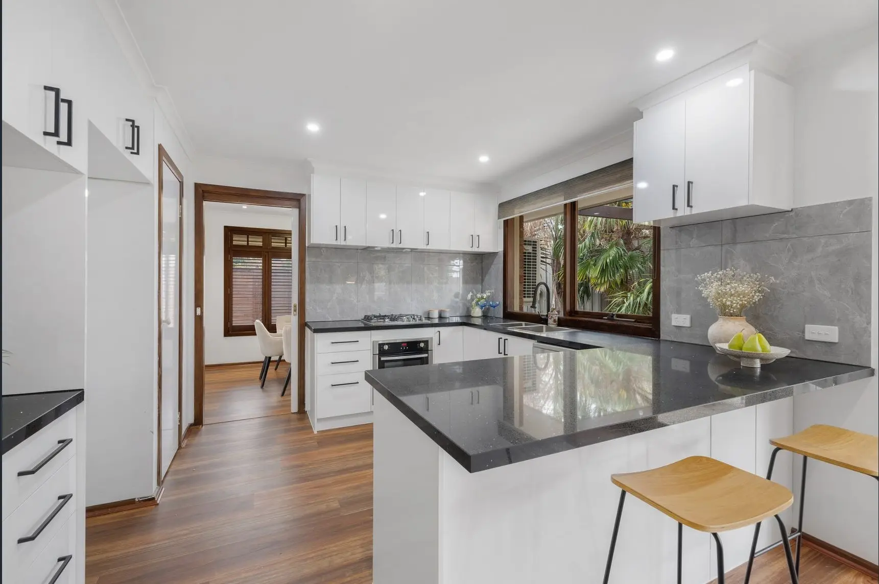 Custom kitchen joinery with modern handles and soft-close drawers.