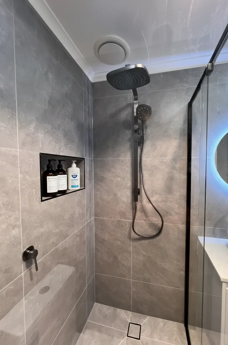 Walk-in shower with black fixtures in a modern bathroom remodel