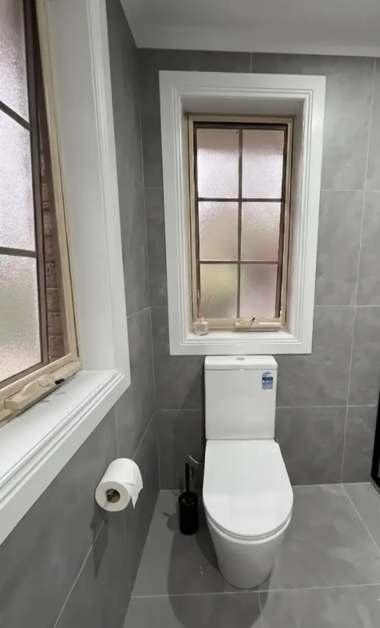 Modern bathroom renovation with glass shower, white vanity, and storage upgrades