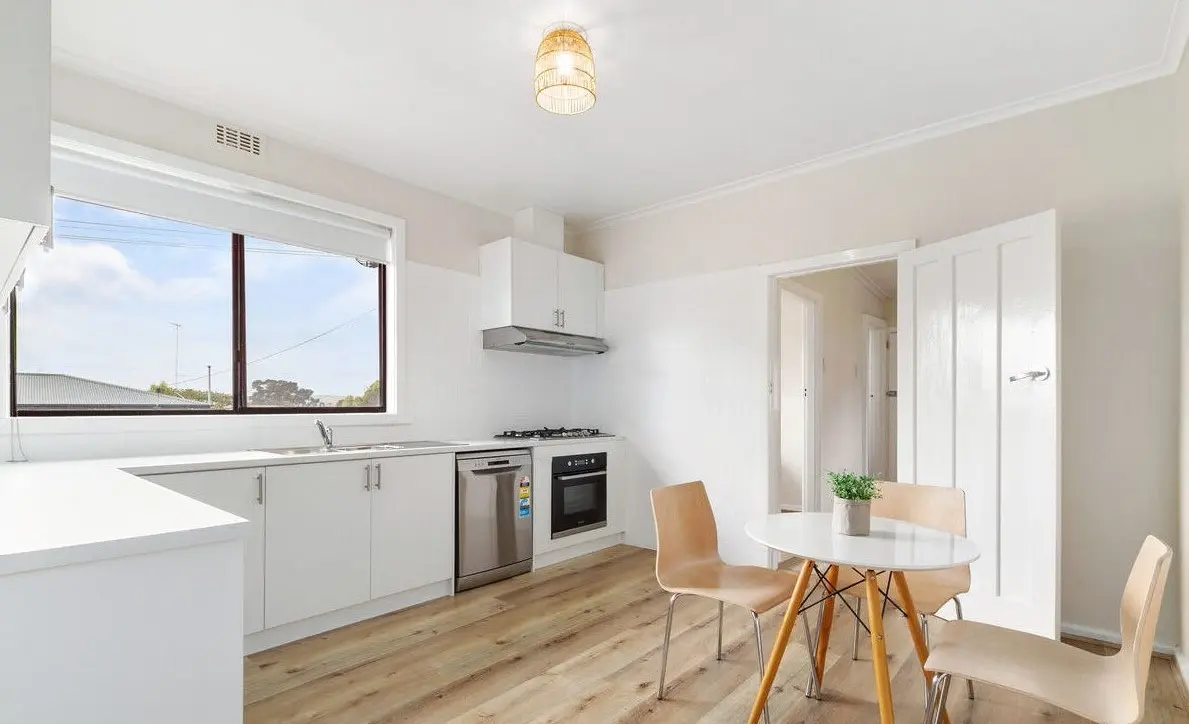 Cheap kitchen remodel Churchill with modern white cabinets and hybrid timber flooring.