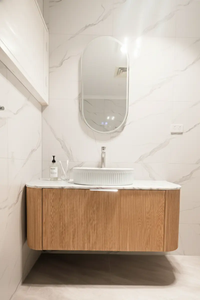 Fluted Woodland Oak wall-hung vanity with stone benchtop in modern bathroom remodel.