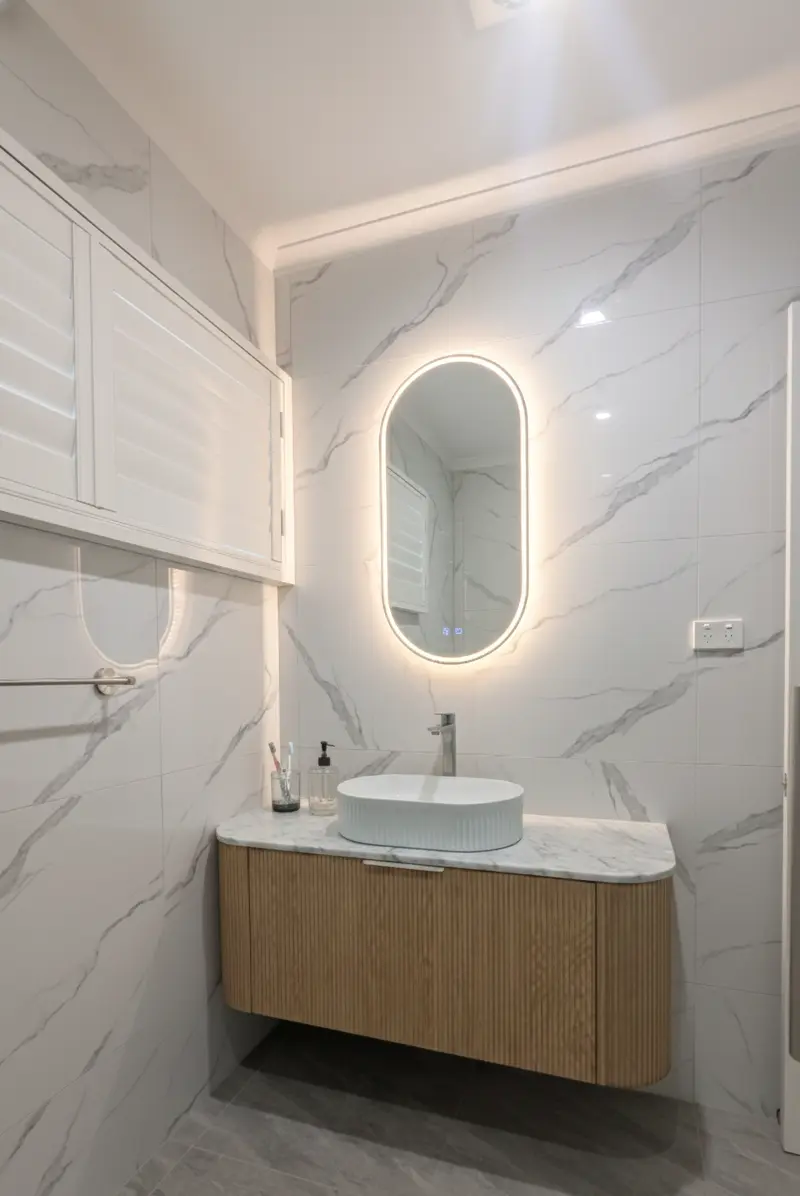 Modern bathroom renovation in Mt Waverley with fluted vanity and LED mirror.