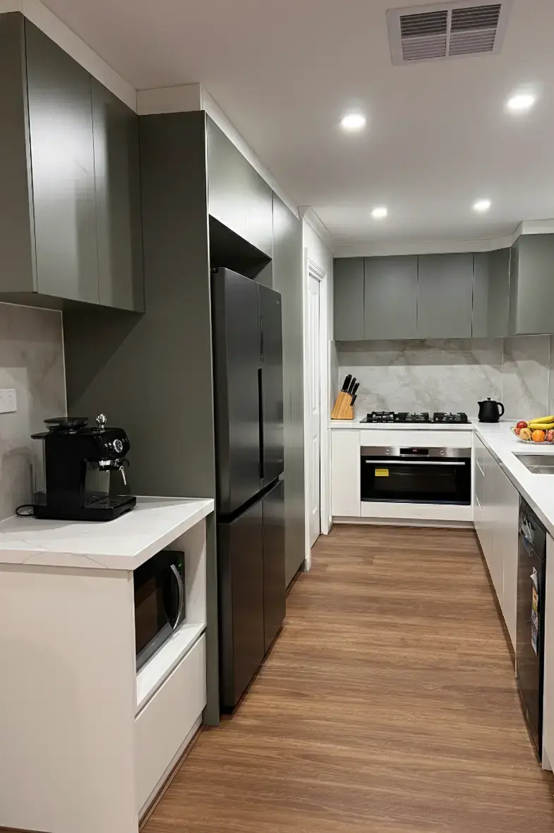 Modern kitchen renovation with two-tone cabinetry, stone benchtop, Taj Mahal stone splashback, LED lighting and hybrid flooring.